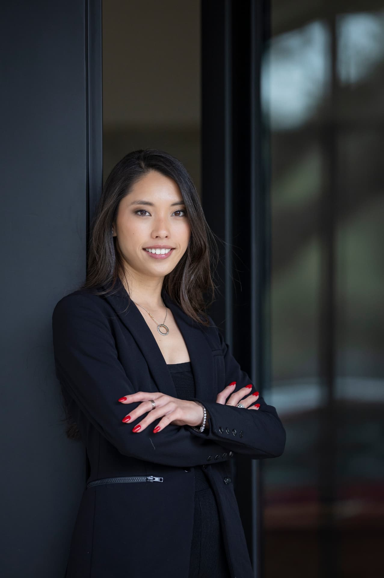 Alyssa Nguyen leaning against a dark modern facade in Austin